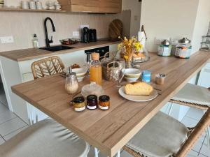 a wooden table with food on it in a kitchen at Le Citrus - Séjour cosy en plein centre historique in Montaigu-Vendée