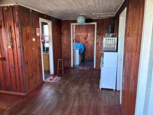 a room with wooden walls and a kitchen with a refrigerator at MiraMar Casa Azul in Puerto Saavedra