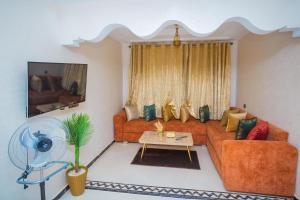 a living room with a couch and a fan at Appartements Meublé Désert Doré Boujdour in Cabo Bojador