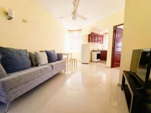 a living room with a couch and a kitchen at Costambar Ocean Breeze - Beachfront Apartment with Pool in San Felipe de Puerto Plata