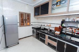 a kitchen with a refrigerator and a stove at Appartements Meublé Désert Doré Boujdour in Cabo Bojador