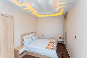 a bedroom with a large bed with a ceiling at Appartements Meublé Désert Doré Boujdour in Cabo Bojador