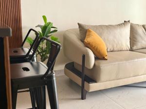 a couch with a yellow pillow next to a chair at Sree Devi Grande in Chennai