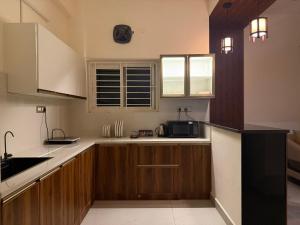 a kitchen with wooden cabinets and a microwave at Sree Devi Grande in Chennai