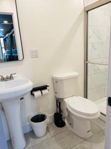 a white bathroom with a toilet and a sink at KAMA CENTRAL PARK in New York