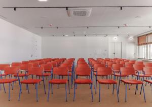 a room with rows of red chairs in it at Upon Harbor - Seixal Bay Hotel in Seixal +100 photos
