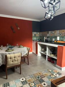a dining room with a table and a kitchen at Tiny harties in Hartbeespoort
