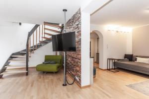 a living room with a couch and a tv at ötztalLOFT in Längenfeld