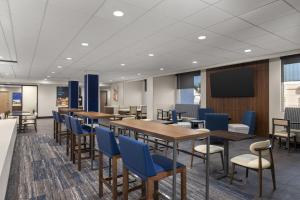 a conference room with tables and chairs and a screen at Holiday Inn Express & Suites Phoenix - Midtown, an IHG Hotel in Phoenix