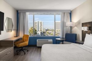 a hotel room with a bed and a desk and a window at Holiday Inn Express & Suites Phoenix - Midtown, an IHG Hotel in Phoenix +35 photos
