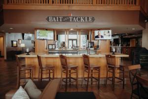 a bar in a restaurant with chairs and a counter at Wildwood Lodge in Pewaukee +56 photos