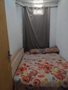 a bedroom with a bed with a floral bedspread at Quarto para carnaval Olinda e Recife in Paulista