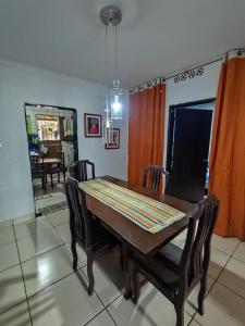 a dining room with a table and chairs and a mirror at Quarto para carnaval Olinda e Recife in Paulista