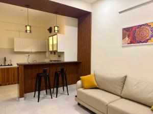 a living room with a couch and a kitchen at Sree Devi Grande in Chennai