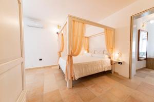 a bedroom with a canopy bed and a mirror at La Curte - B&B in Melendugno