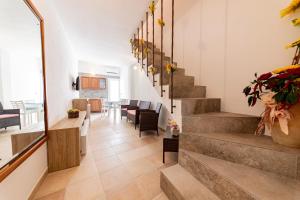 a hallway with stairs in a house with flowers at La Curte - B&B in Melendugno