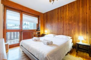 a bedroom with a large bed with towels on it at Hostdomus - Clotes 33 in Sauze d'Oulx