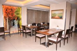 a restaurant with wooden tables and chairs and a painting at Asrin Business Hotel Kızılay in Ankara