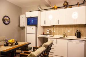 a kitchen with white cabinets and a table with chairs at Seten House in Ürgüp