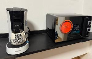 Eine Kaffeemaschine neben einer Mikrowelle auf der Arbeitsfläche in der Unterkunft FERTILE in Charleroi + 5 Fotos