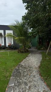 a cobblestone path in front of a house with a palm tree at Apartamento Zion reserve suites in Conde