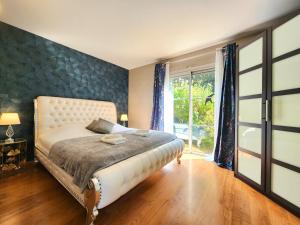 a bedroom with a bed and a large window at Symphony - in Saint-Emilion in Saint-Émilion