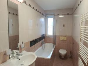 a bathroom with a tub and a toilet and a sink at Central apartment in Staré Mesto +9 photos