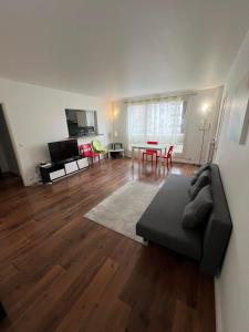 a living room with a couch and a table at Private Room in a Shared Appartment in Asnières-sur-Seine