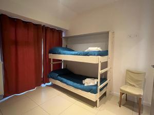 two bunk beds in a room with a chair at Caraceni Apartaments 1 in Castel di Sangro