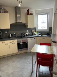 a kitchen with a table and a stove top oven at Private Room in a Shared Appartment in Asnières-sur-Seine