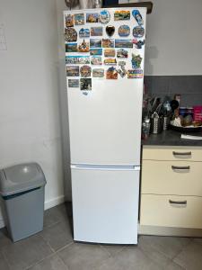 a white refrigerator with many magnets on it in a kitchen at Private Room in a Shared Appartment in Asnières-sur-Seine +12 photos