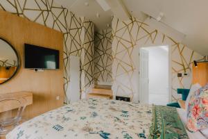a bedroom with a bed and a tv on a wall at The Galaxie in Oxford