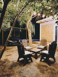 two chairs and a picnic table under a tree at Dormis Talampaya in Villa Unión