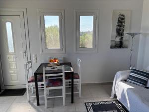 a dining room with a table and chairs and two windows at Captains View in Kefallonia