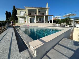 a house with a swimming pool in front of a house at Captains View in Kefallonia