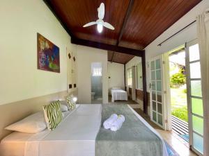 a bedroom with a large bed with a ceiling fan at Atobá Villas in Paraty +95 photos