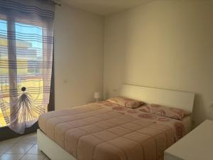 a bedroom with a large bed with a window at Home 14 in Tortoreto Lido