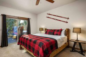 a bedroom with a bed with a red and black blanket at Moose Meadow in Welches
