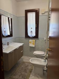 a bathroom with a sink and a toilet and a window at Home 14 in Tortoreto Lido +9 photos