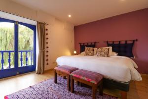 a bedroom with a large bed and a large window at Muru Suites near Plaza de Armas Cusco by Wynwood House in Cusco