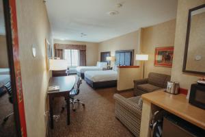 a hotel room with two beds and a desk at Wildwood Lodge in Pewaukee