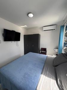 a bedroom with a bed and a tv on the wall at Viva Alto Vista! in Noord
