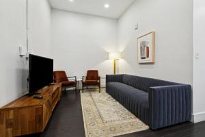 a living room with a couch and a flat screen tv at Ther Gregory Suite 101 ADA in New Orleans