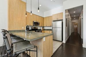 a kitchen with wooden cabinets and a stainless steel refrigerator at Ther Gregory Suite 101 ADA in New Orleans