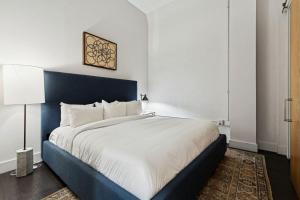 a bedroom with a large bed with a blue headboard at Ther Gregory Suite 101 ADA in New Orleans