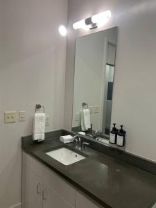 a bathroom with a sink and a large mirror at Ther Gregory Suite 101 ADA in New Orleans +5 photos