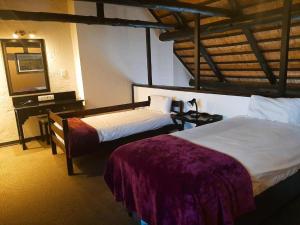 a hotel room with two beds and a mirror at Mount Sheba Rainforest & Resort in Pilgrim's Rest