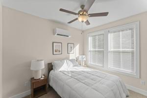 a white bedroom with a bed and a ceiling fan at Riverview Retreat: Neyland Stadium – sleeps 8! in Knoxville