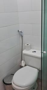 a bathroom with a toilet and a glass shower at Pousada Palladium in Neópolis