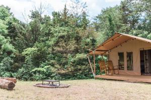 a small tent with a picnic table in a field at GlampKnox Canvas Campground - Grande in Knoxville